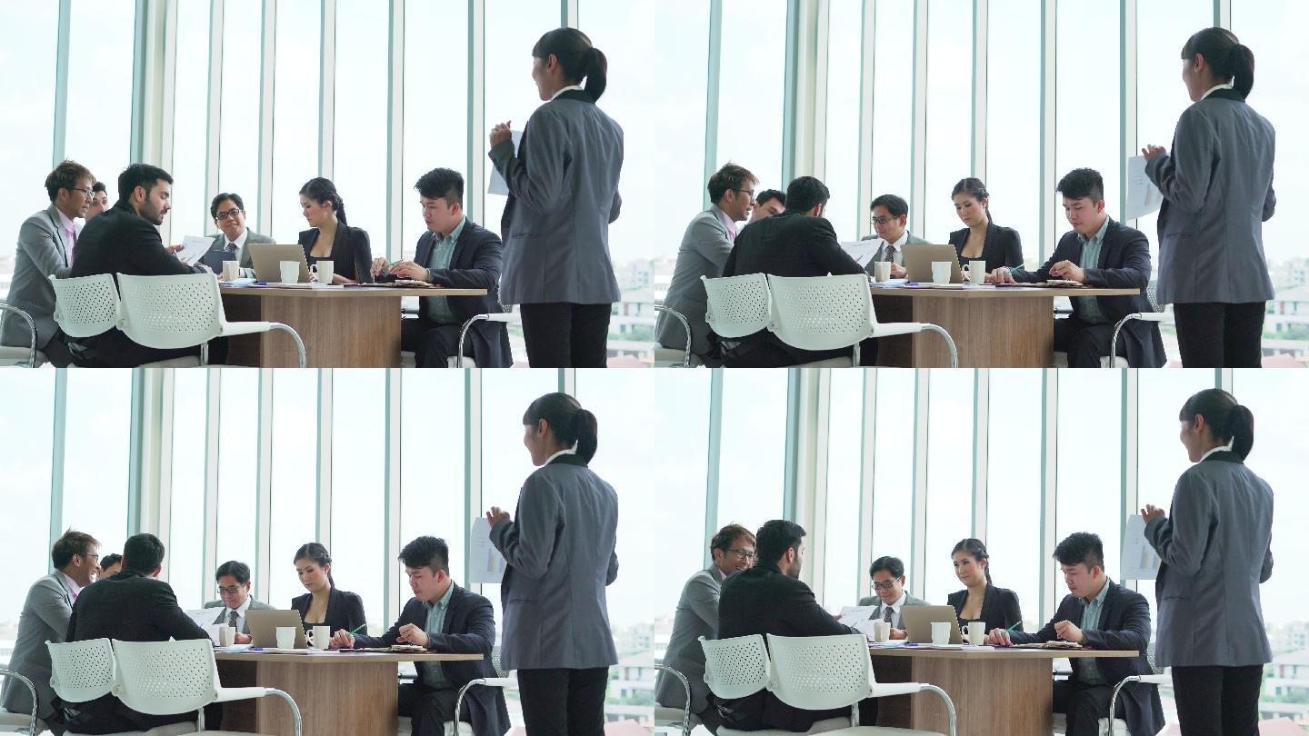 商务女性在会议期间向他的同事做演示
