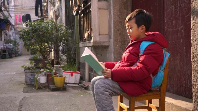 小男孩在巷子里看书
