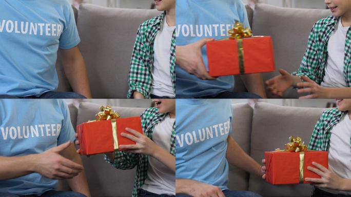 志愿者为低收入家庭的小男孩赠送礼盒