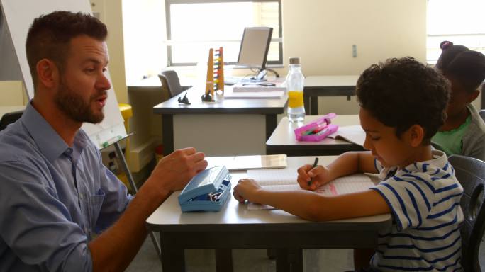 男学生与男老师在教室学习的侧视图。