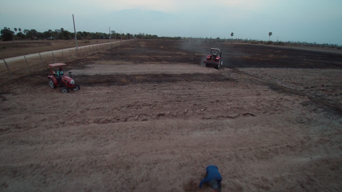 航拍柬埔寨农村拖拉机开垦土地施肥