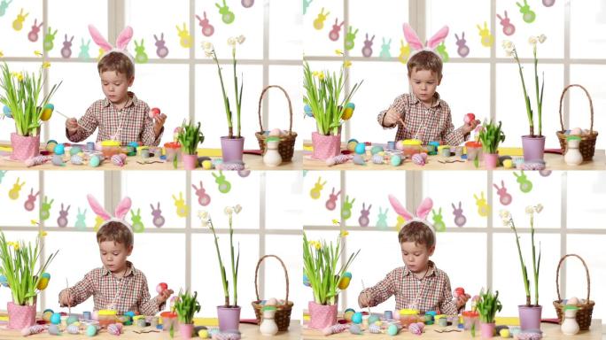 快乐的孩子戴着兔子耳朵在复活节画彩蛋