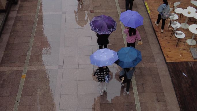雨天街道行人打伞逛街