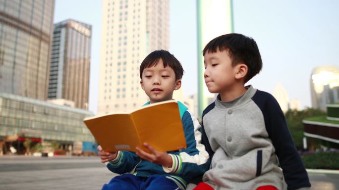 两个小男孩坐在路边看书