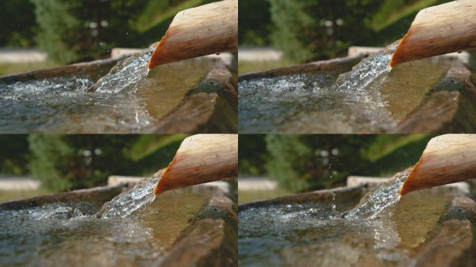清澈的水流通过木管流入石盆