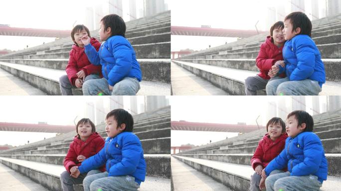 两个小男孩坐在梯子上玩