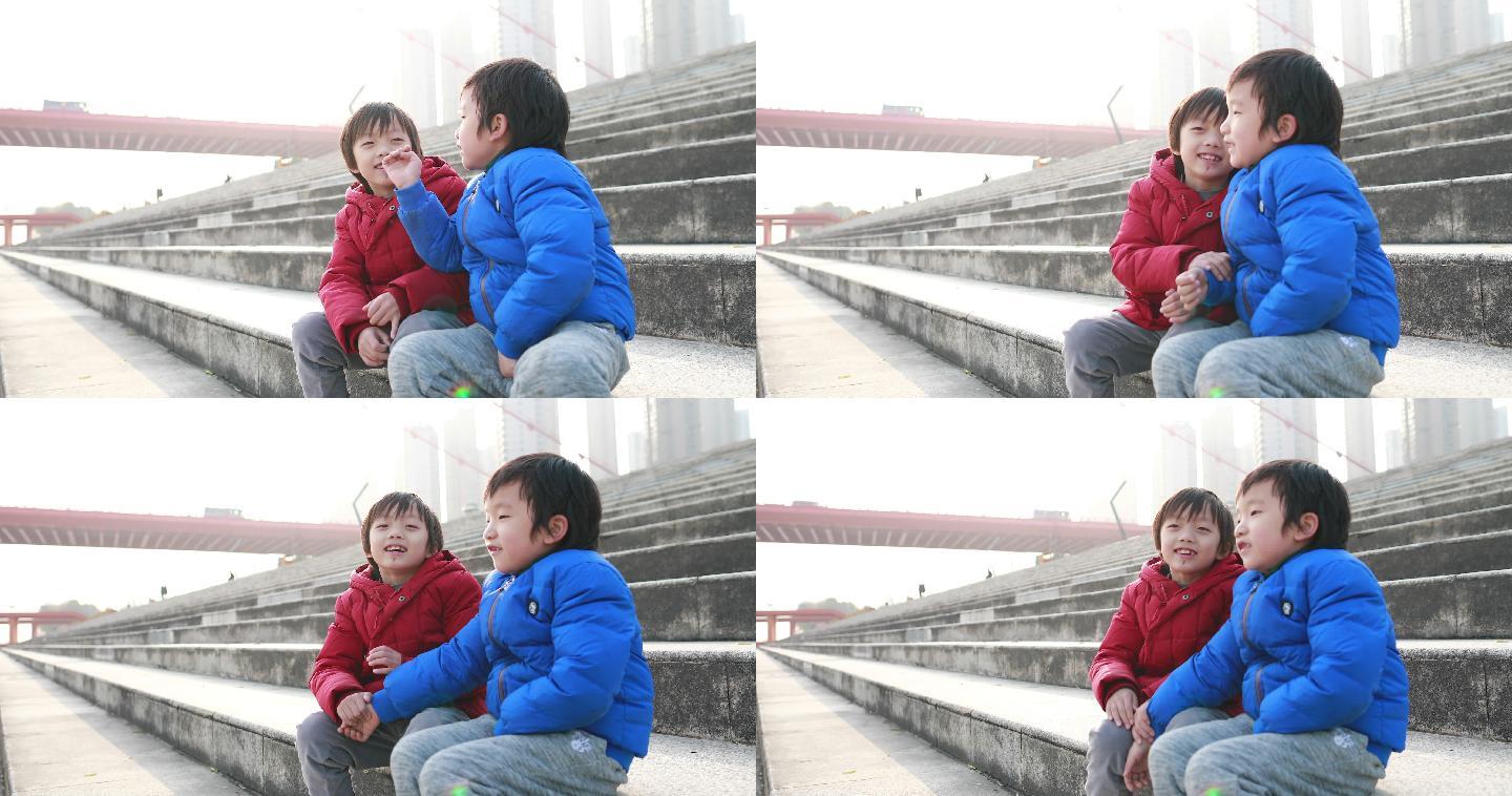两个小男孩坐在梯子上玩