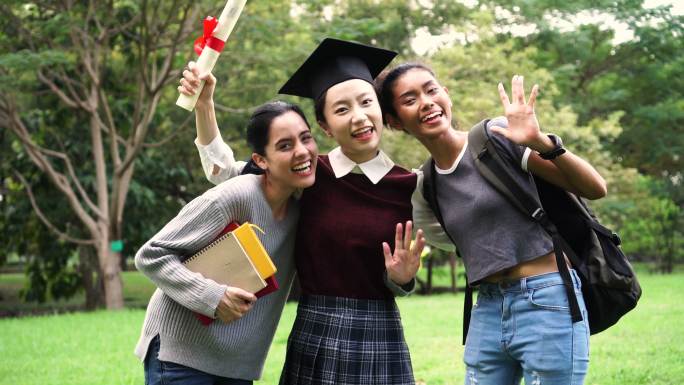 年轻的女毕业生和她的朋友们拍照