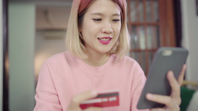 女人使用智能手机在网上购物通过信用卡