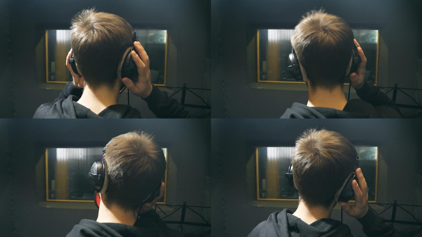 年轻人戴着耳机在录音室里唱歌。