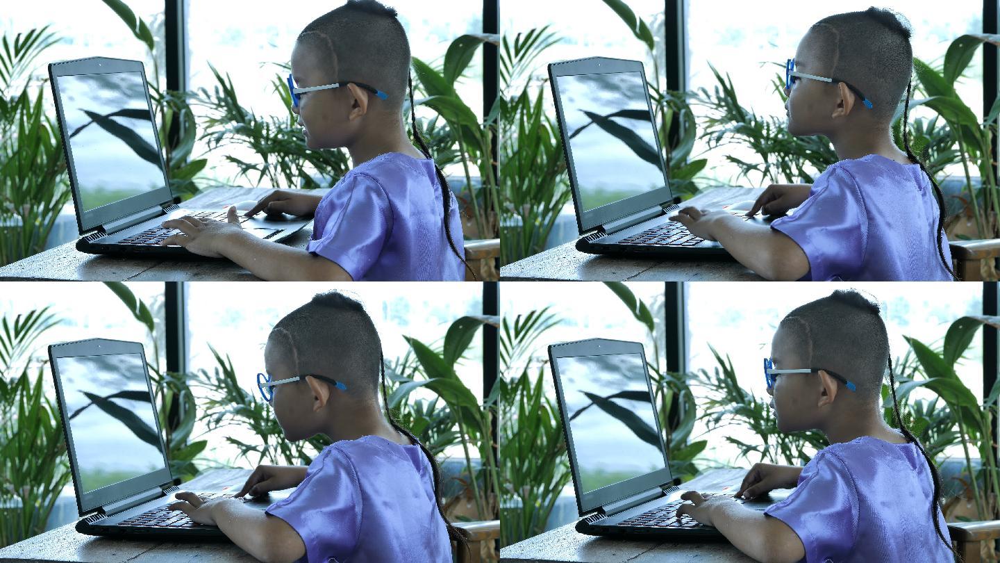 快乐的小男孩使用笔记本电脑