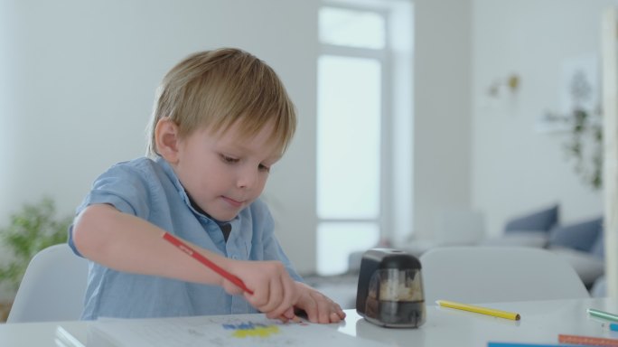 男孩在纸上画彩笔