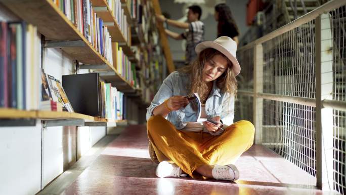 戴着帽子的年轻女士在一家大书店里看书