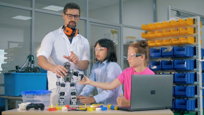学校科学老师向聪明的学生展示机器人技术。