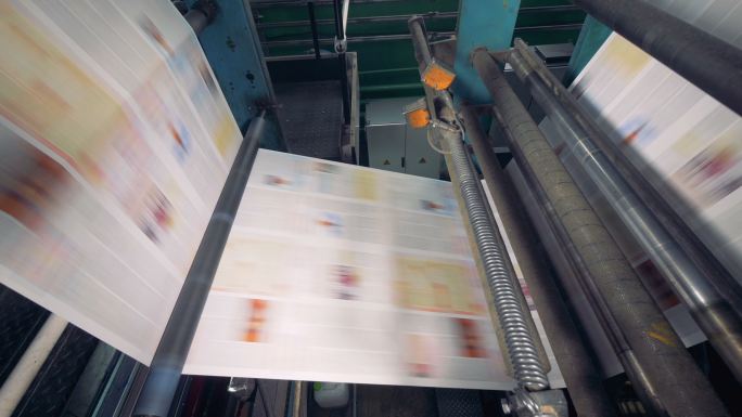 在工厂里，纸张快速地通过传送带传送。
