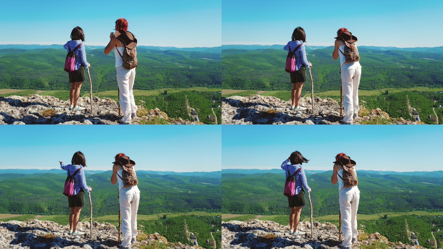 两个女孩旅行者女友走在一个高山高原上