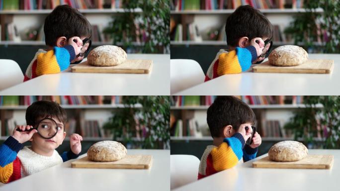 小男孩用放大镜看酸面包。