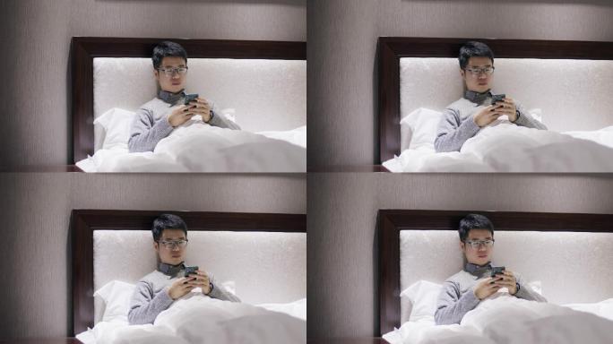 4K年轻男性出差在酒店床上躺着玩手机