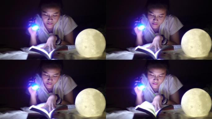女孩在卧室里看书挑灯夜读用功学习刻苦钻研
