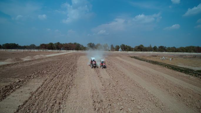 航拍柬埔寨农村拖拉机开垦土地施肥