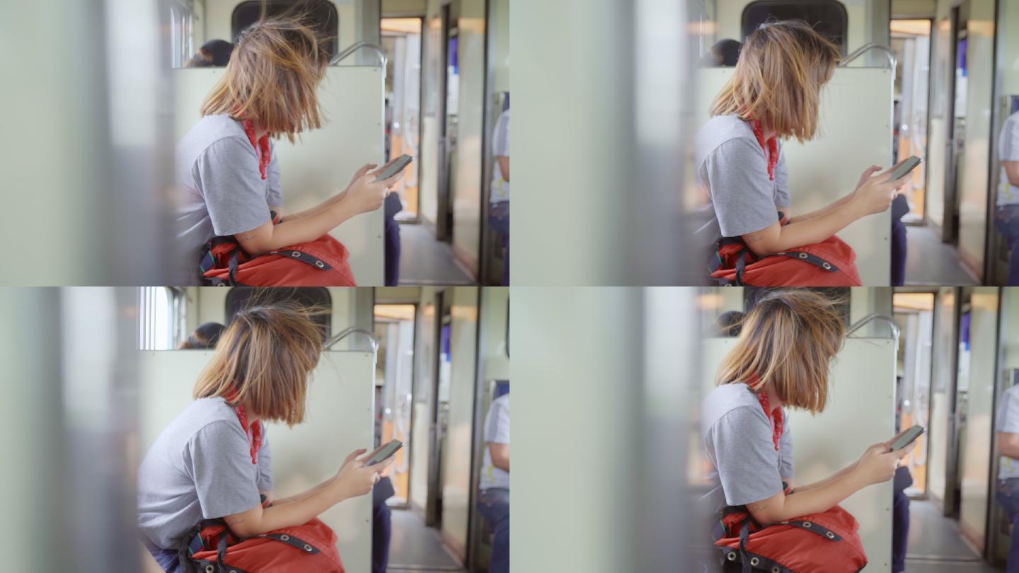 一名女性在坐火车时用智能手机听音乐放松