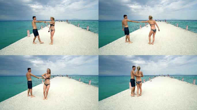 快乐浪漫的情侣在海滩码头微笑跳舞