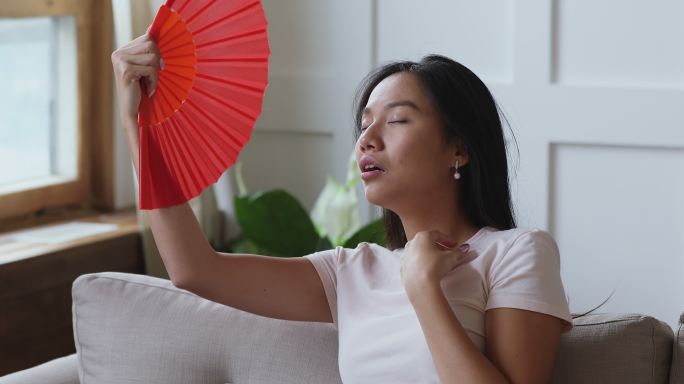 年轻女人用扇子扇风