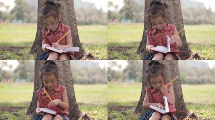 可爱的小女孩在公园画画。教育的概念。