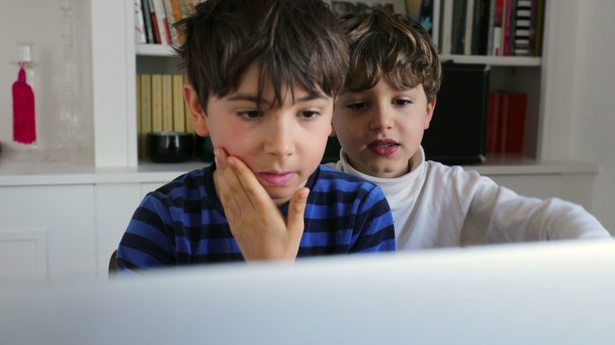 孩子们坐在电脑屏幕前。