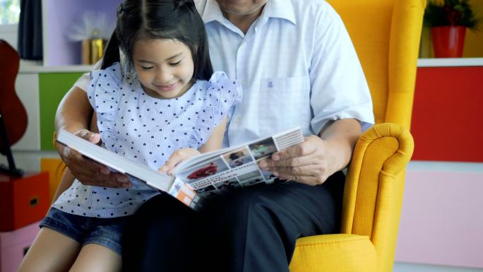 老爷爷和小孙女一起在家看书