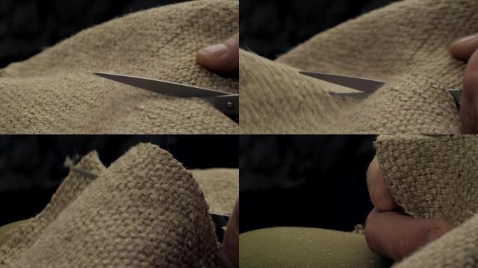 女裁缝用剪刀剪黄麻织物。