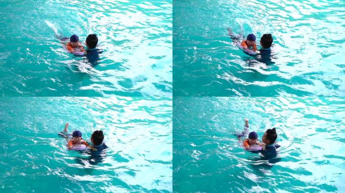 小女孩在游泳池和教练一起学习游泳
