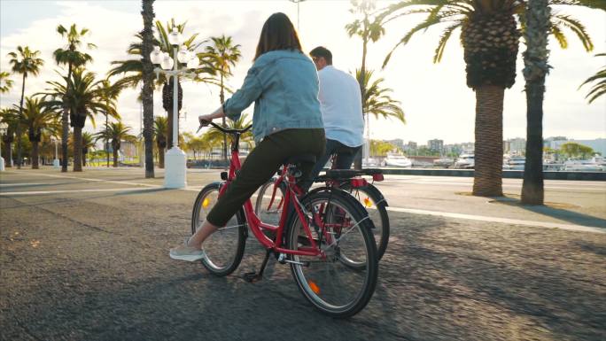 年轻夫妇骑自行车青年男人市区路自行车道