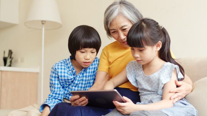 祖母和孙子看数字平板电脑。