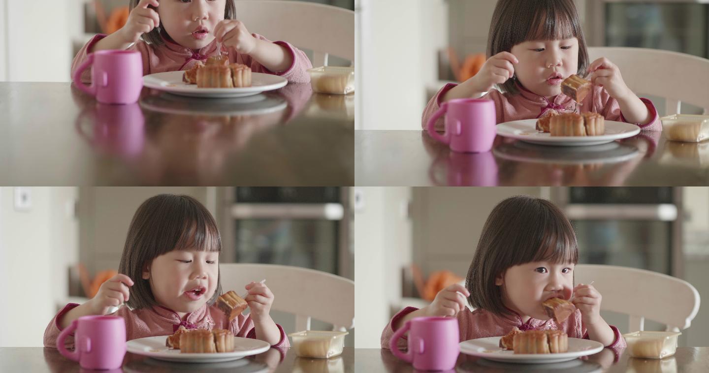 小女孩在中秋节坐在厨房吃月饼