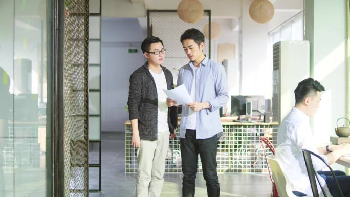 两个年轻的亚洲商人在办公室讨论