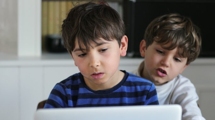 孩子们在电脑前上网看网络媒体内容