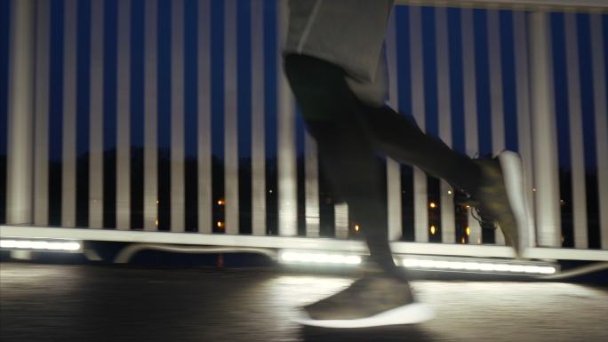 运动员晚上在城市桥上慢跑。
