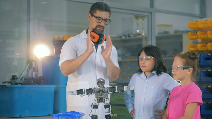 老师向学生展示机器人技术