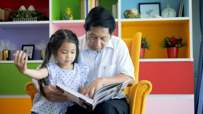 老爷爷和小孙女一起在家看书