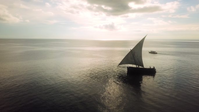 无人机拍摄的日落时分海上帆船的画面