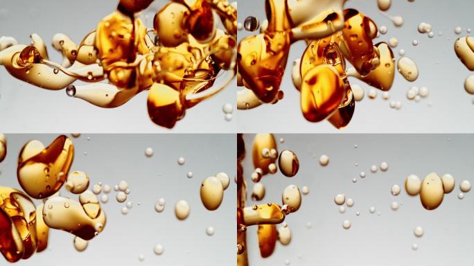 透明的橙色黄金油泡沫在白色梯度背景。