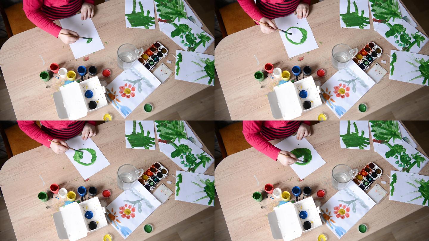 孩子们的手在纸上的木桌表面画水彩画
