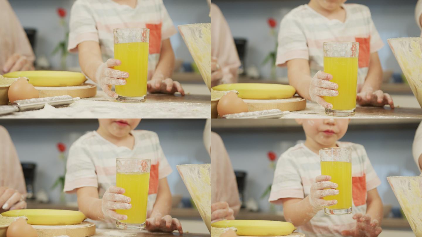 男孩在厨房里喝橙汁。