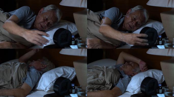 一个沮丧的老人躺在床上无法入睡