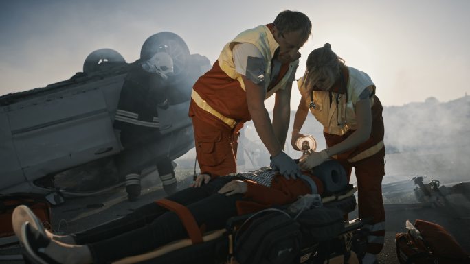 医护人员抢救躺在担架上的女性受害者的生命