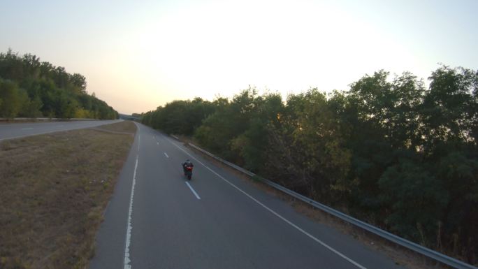 一个男人骑着现代摩托车在高速公路上飞驰。