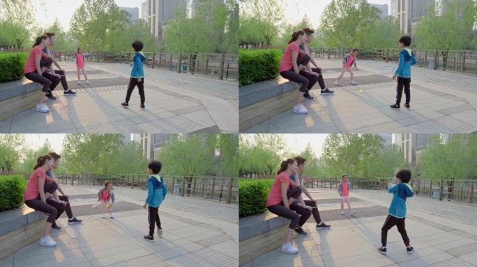 快乐的年轻家庭在公园打羽毛球