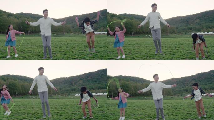 快乐的家庭在草地上比赛跳绳