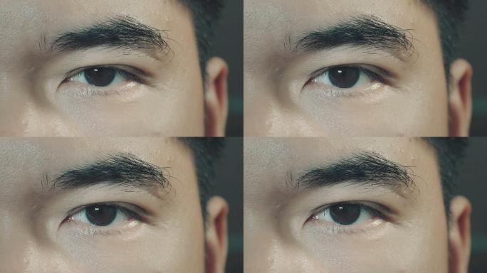 亚洲男性棕色眼睛的特写看着相机